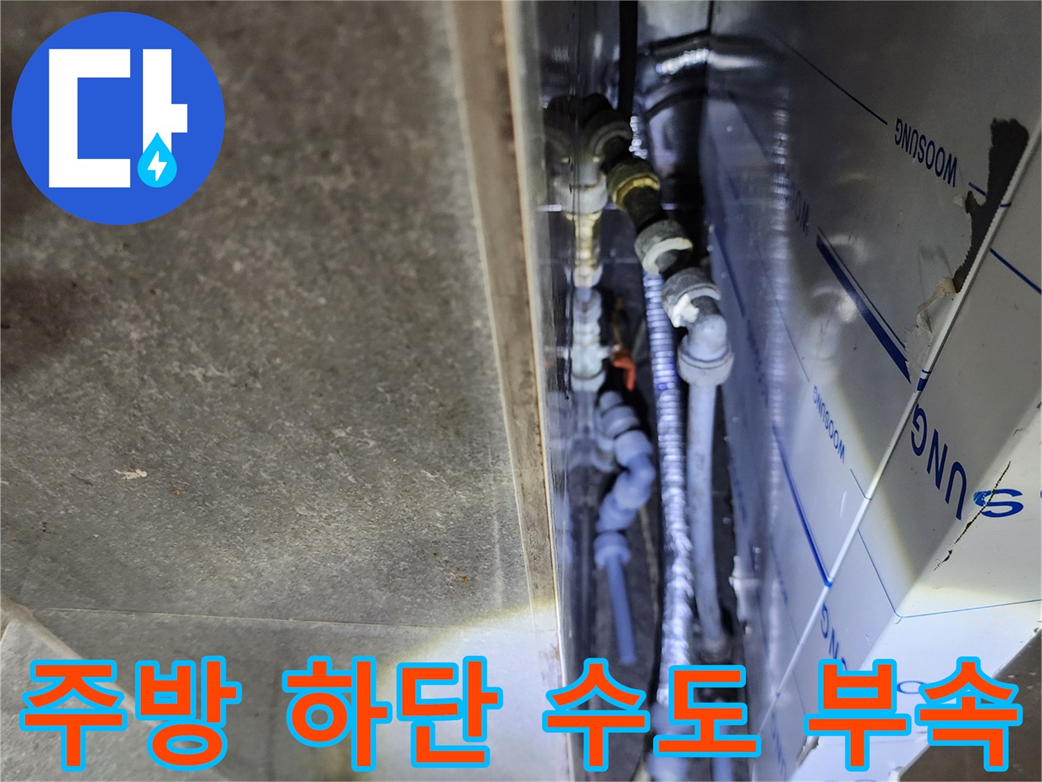 복잡하게 얽힌 주방 하부의 은색 금속 배관들