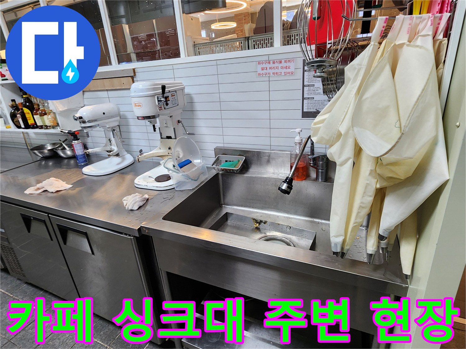 싱크대와 각종 조리 도구가 배치된 카페 주방의 모습 - 누수 지점 확인을 위한 점검 중