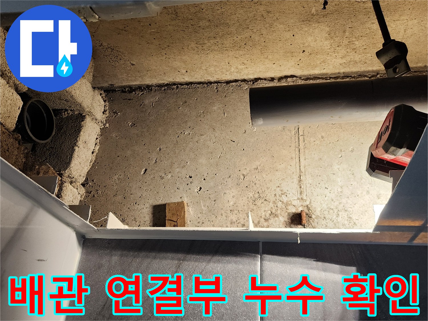 배수관과 벽면 사이의 습한 상태를 보여주는 점검구 내부 사진