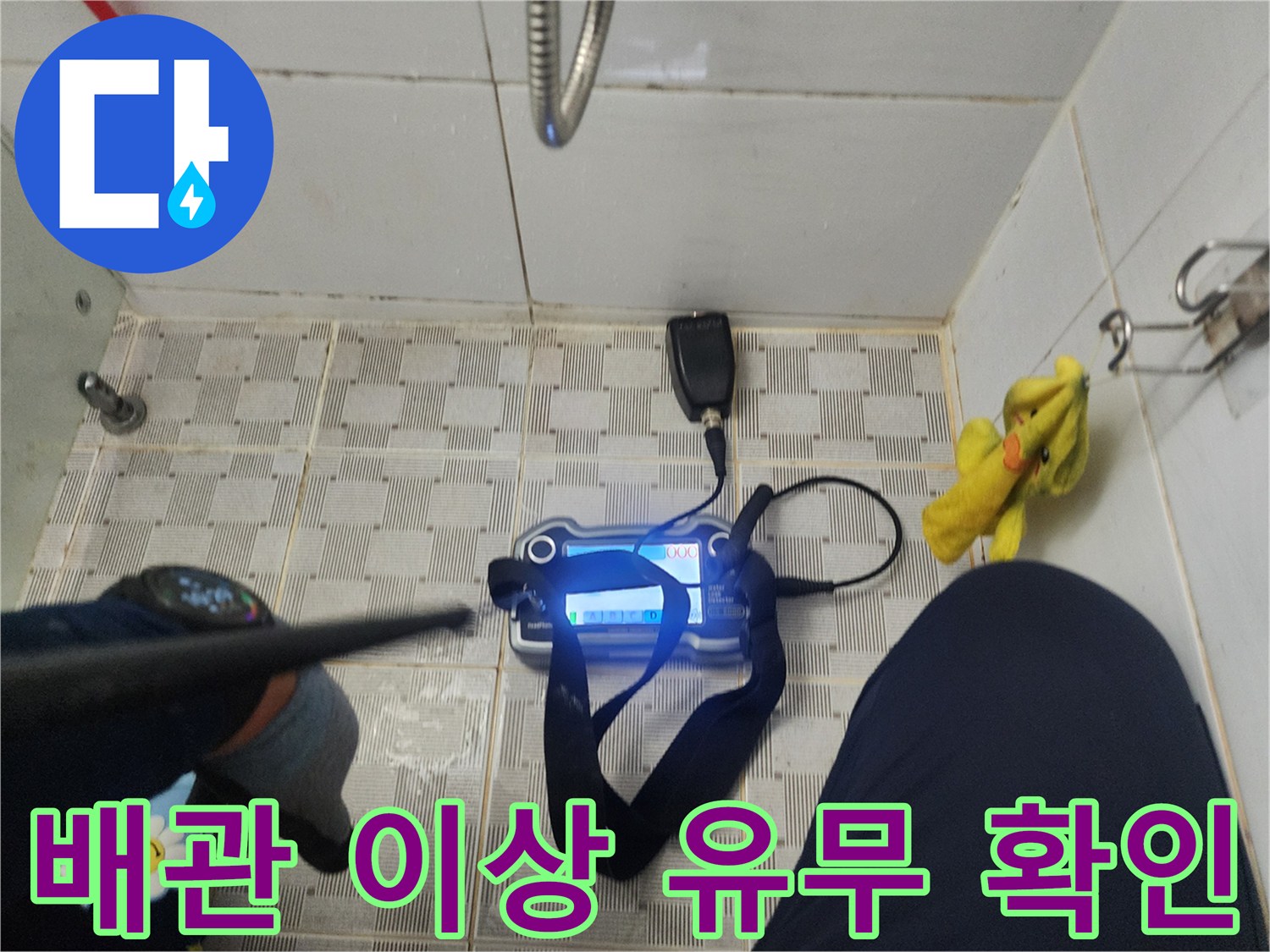 바닥 타일 위에서 가스 탐지 장비를 조작하며 누수 지점을 찾는 엔지니어의 손길