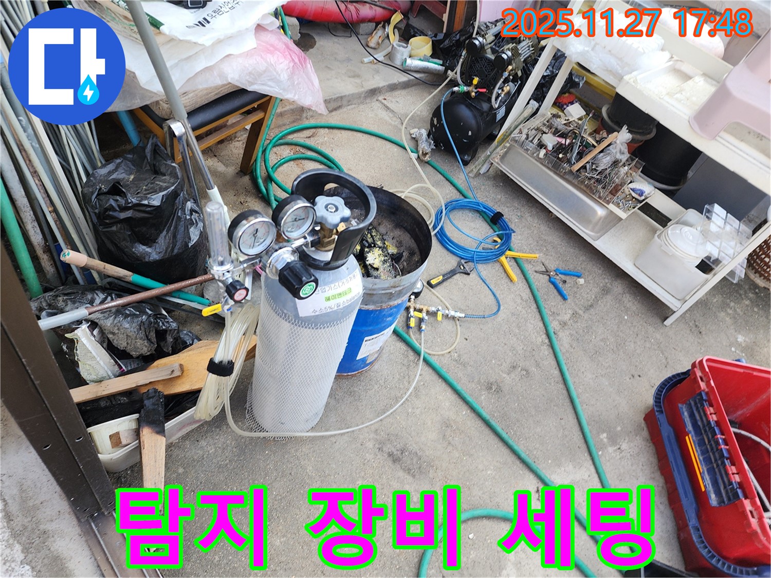 누수 탐지를 위한 장비 세팅 완료 - 압력 게이지, 가스통, 호스 등 모든 준비 완료.