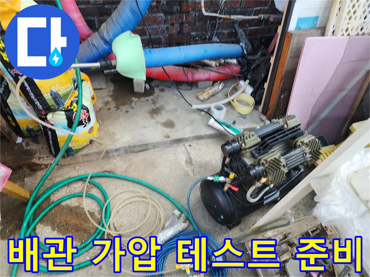 바닥에 놓인 호스와 압력 측정용 펌프 장비의 모습