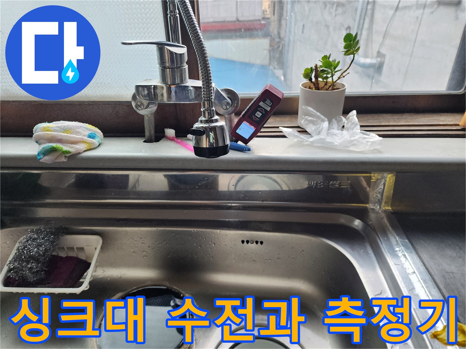 싱크대 수전 옆에 놓인 디지털 온도계와 청소 도구