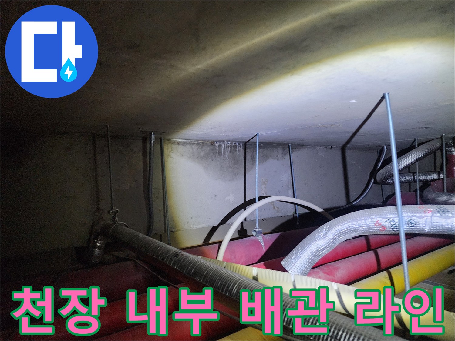 복잡하게 얽힌 천장 속 배관과 습기 흔적이 남은 벽체