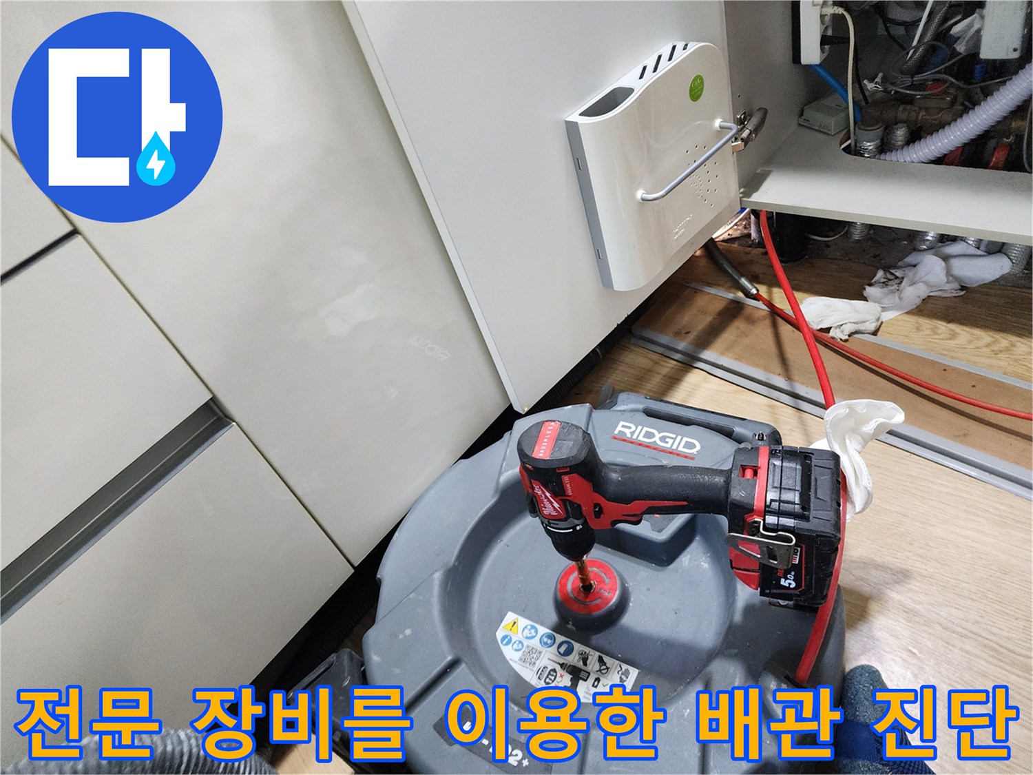 싱크대 아래 공간에서 사용될 전문 내시경 카메라와 드릴 공구의 모습입니다.