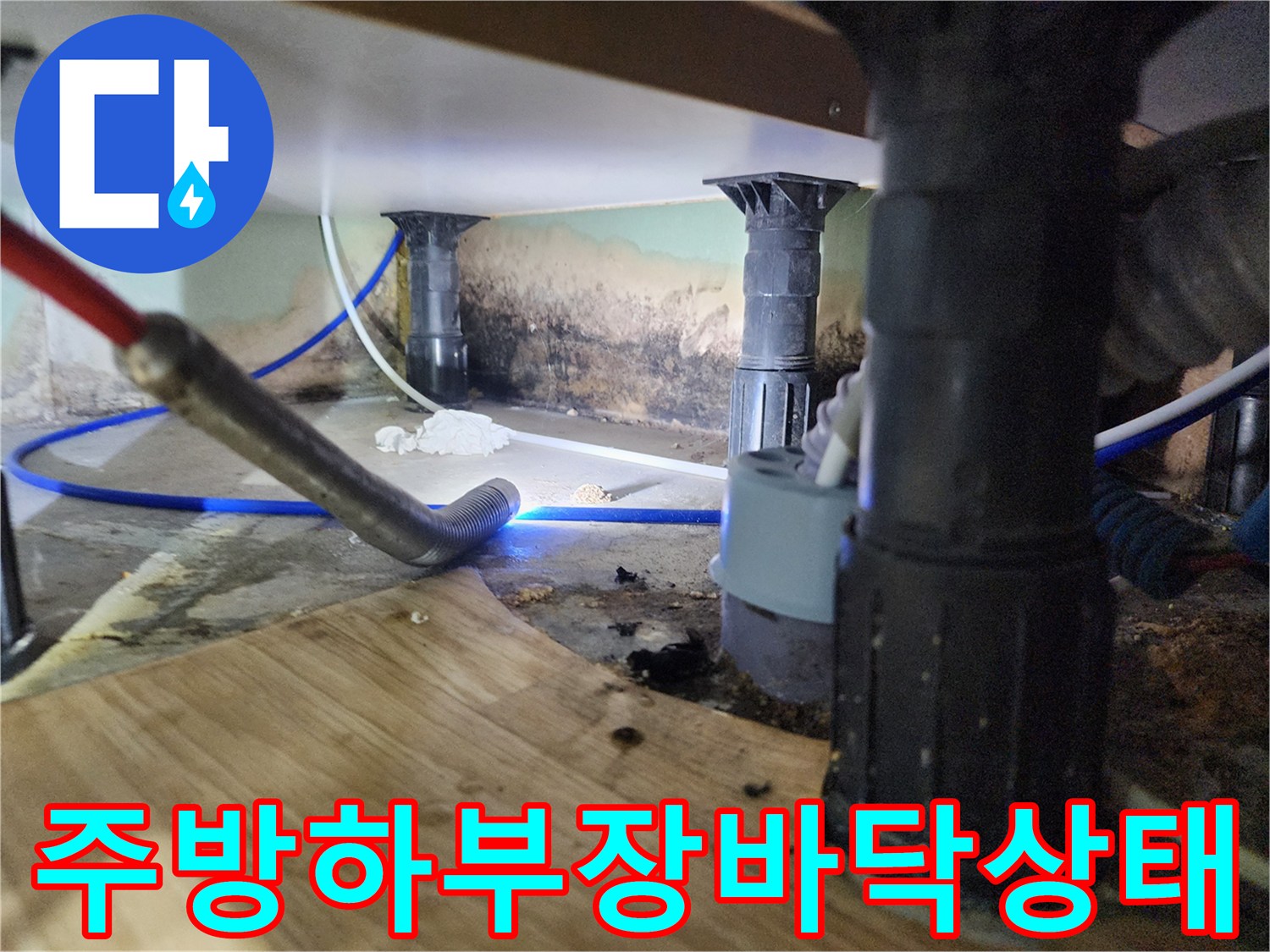 싱크대 하부 공간의 배관 주변과 바닥 얼룩 상태를 보여주는 사진입니다.