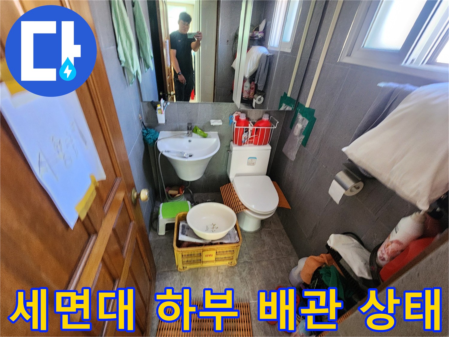 화장실 세면대 아래쪽의 배수관과 주변 환경 점검 중