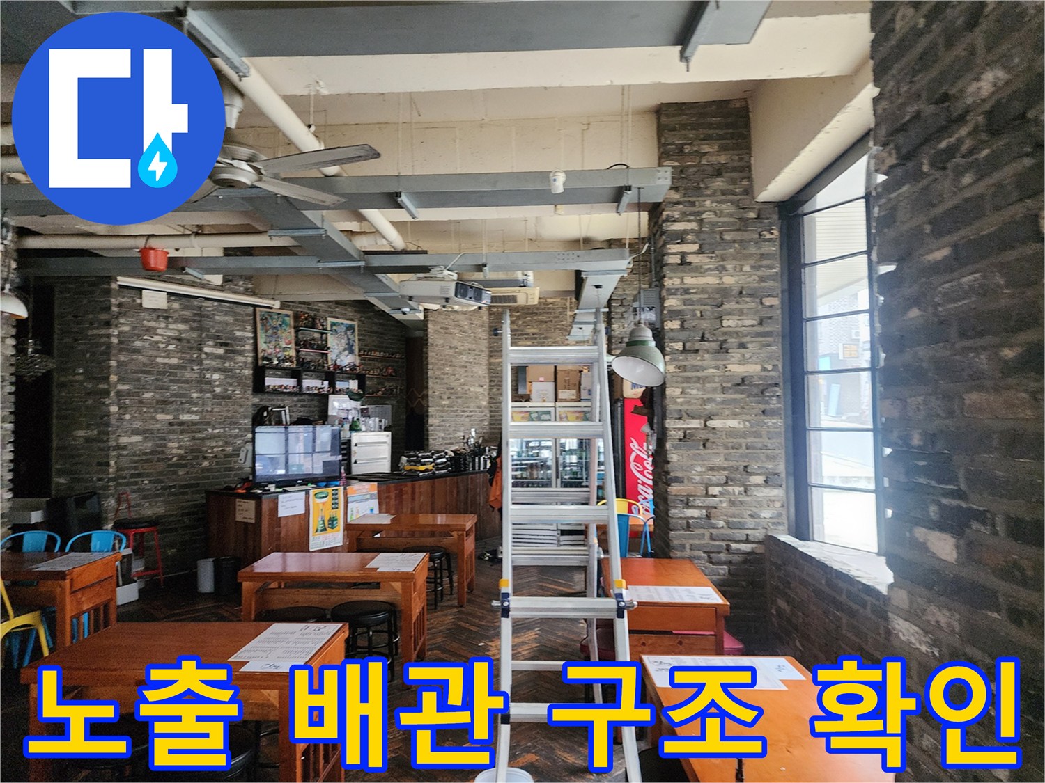 카페 내부 천장의 노출된 배관과 조명 기구 주변 상태