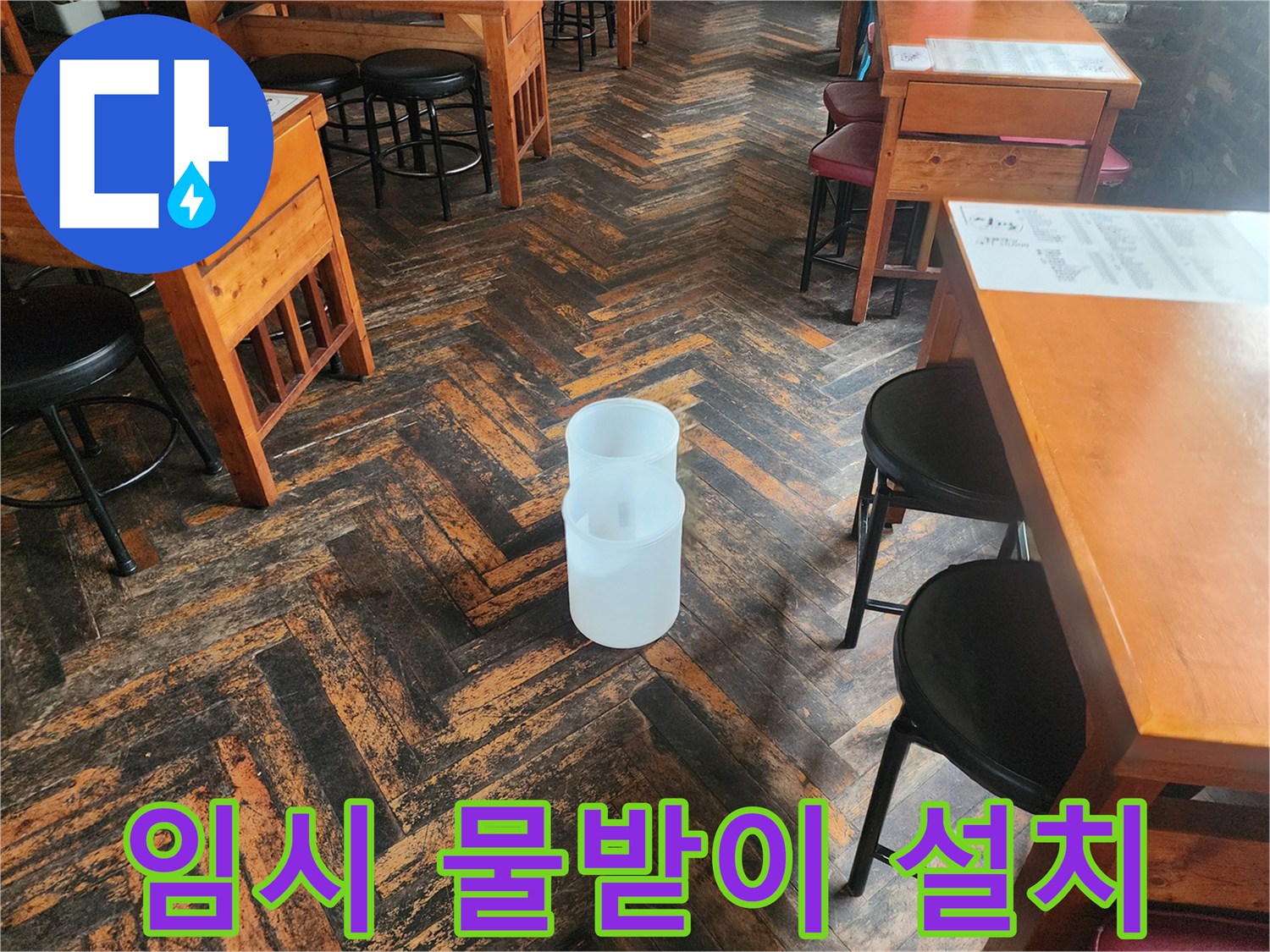 카페 테이블 사이 놓인 하얀색 플라스틱 통