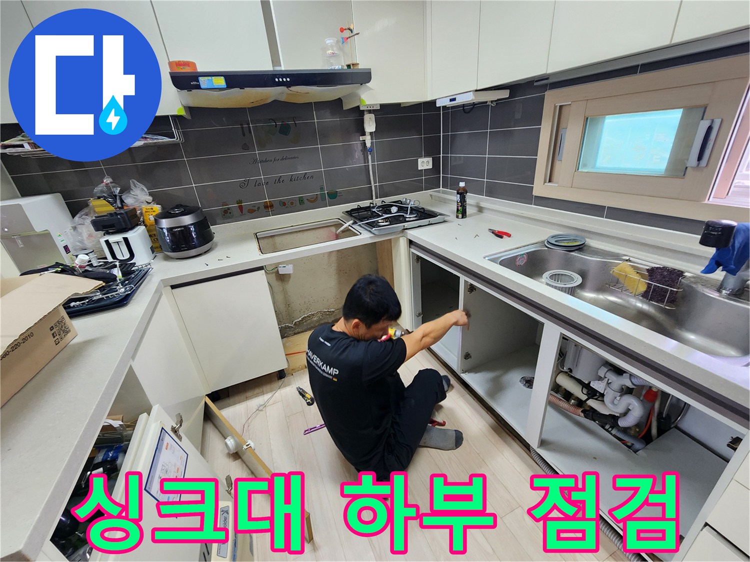 싱크대-하부장을-열어-배관-주변을-점검하는-엔지니어