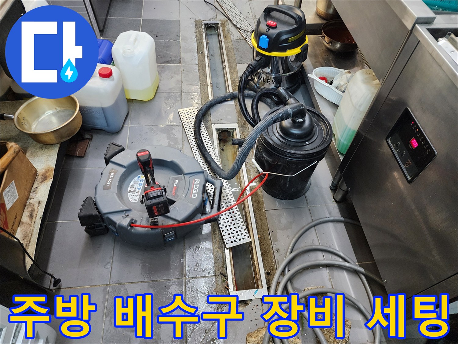 식당 주방 트렌치 주변에 배치된 전문 배관 청소 장비들