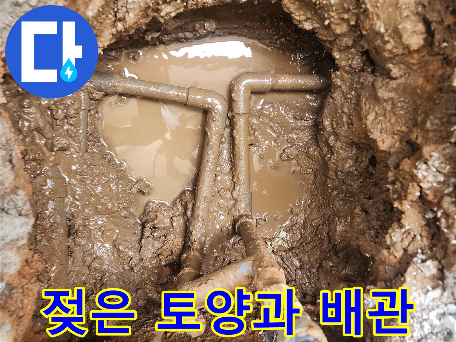 물에 젖어 진흙처럼 변한 토양 속의 파손된 배관 연결부 모습