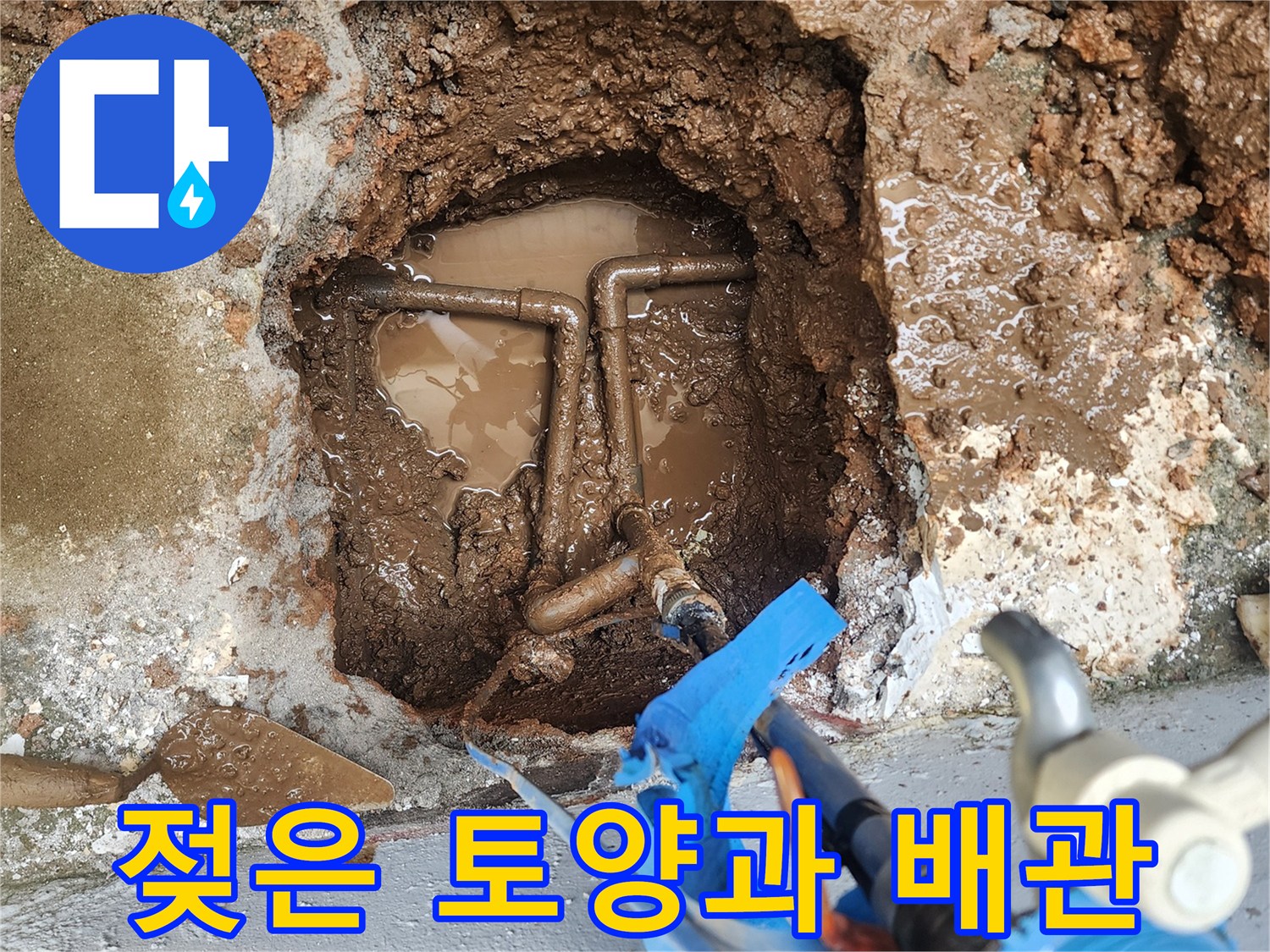 물에 젖은 흙 속에서 발견된 파손된 배관의 연결 부위 모습입니다.
