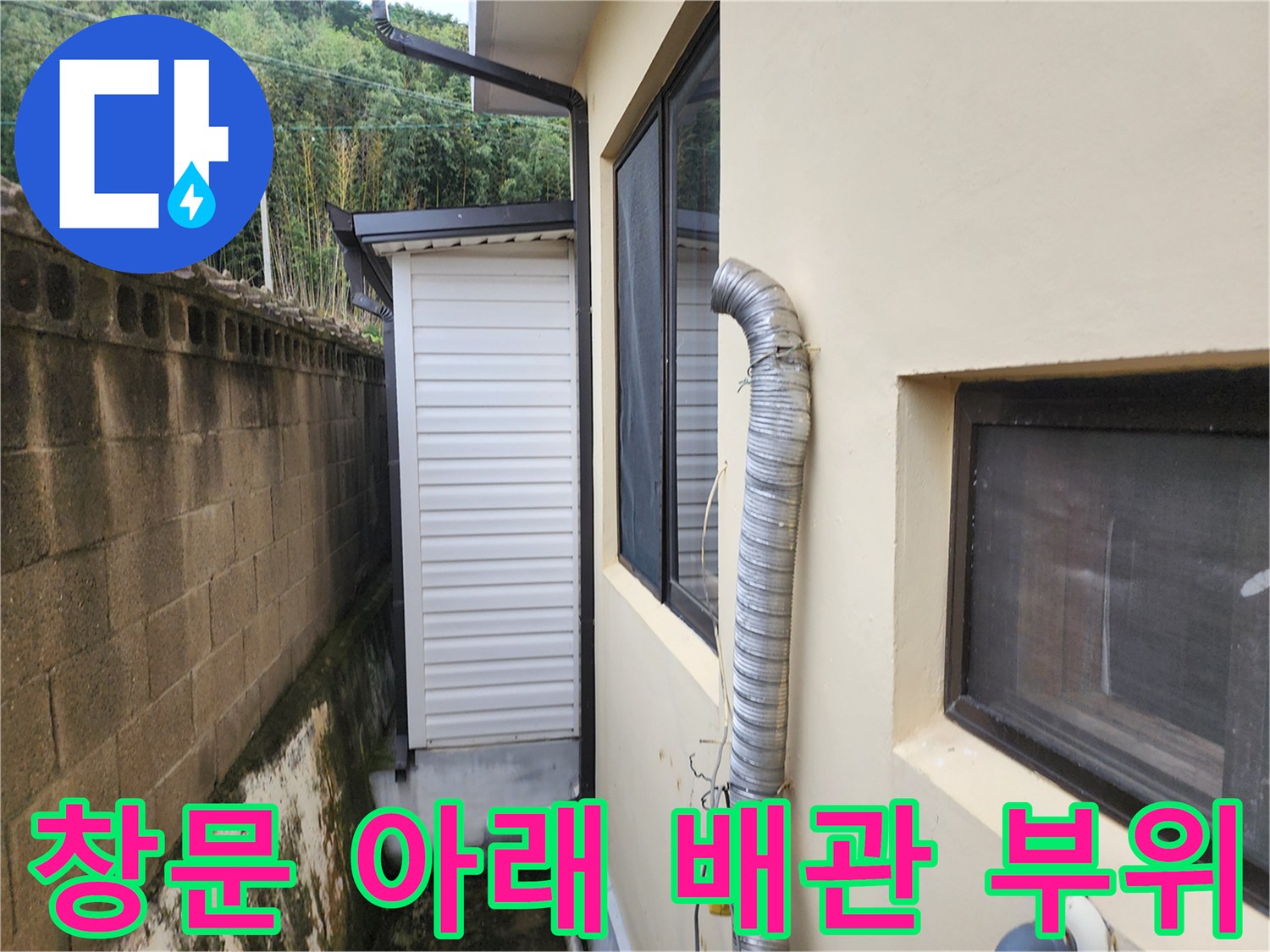외벽 창문 옆에 연결된 굴곡진 은색 배관 상세