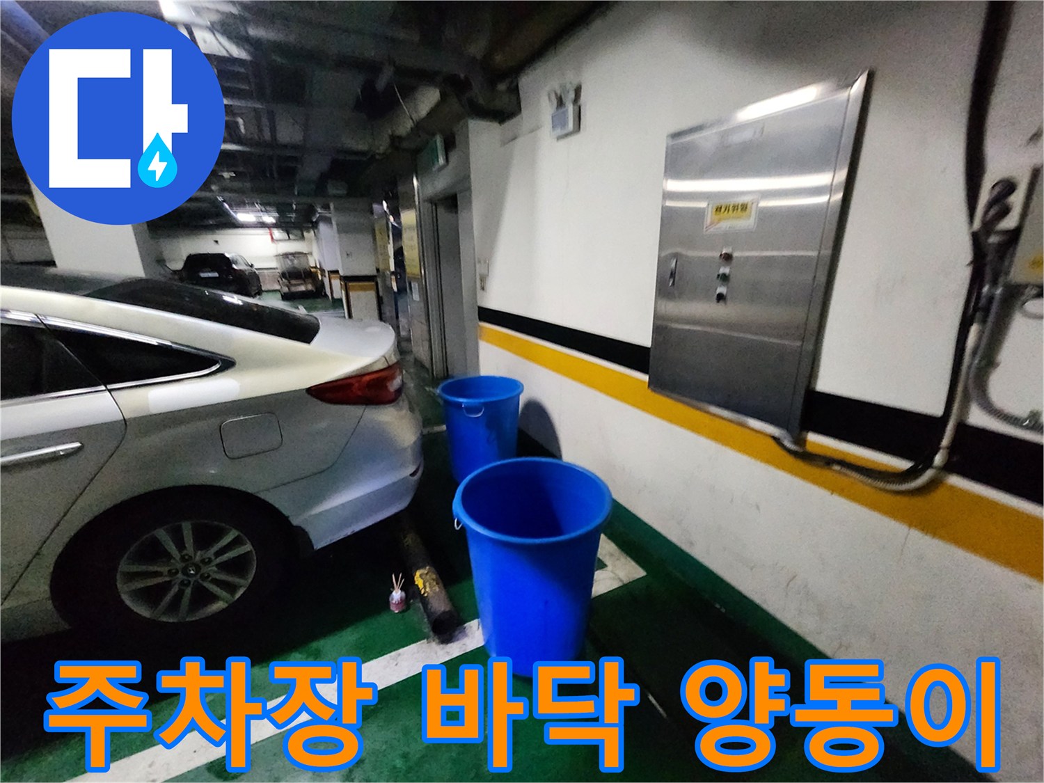 지하 주차장 벽면 하단에 파란색 양동이가 놓여 있는 모습