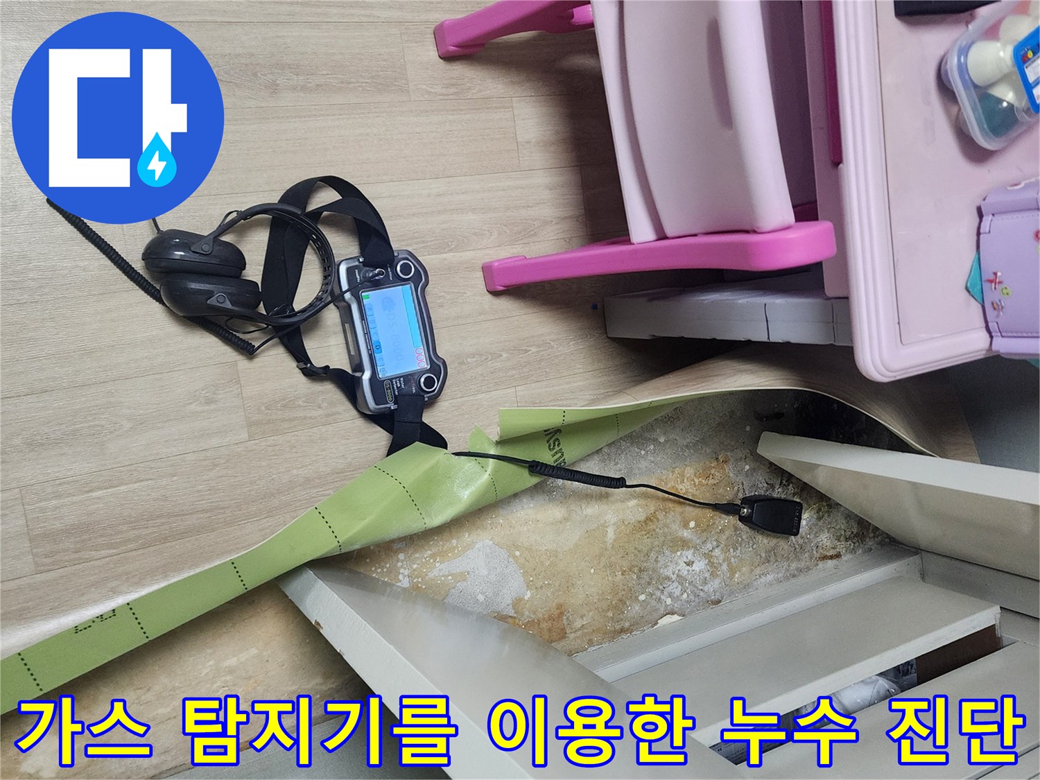 바닥 틈새 부분에 가스 탐지기 센서를 근접시켜 배관의 파손 여부를 확인하고 있습니다.