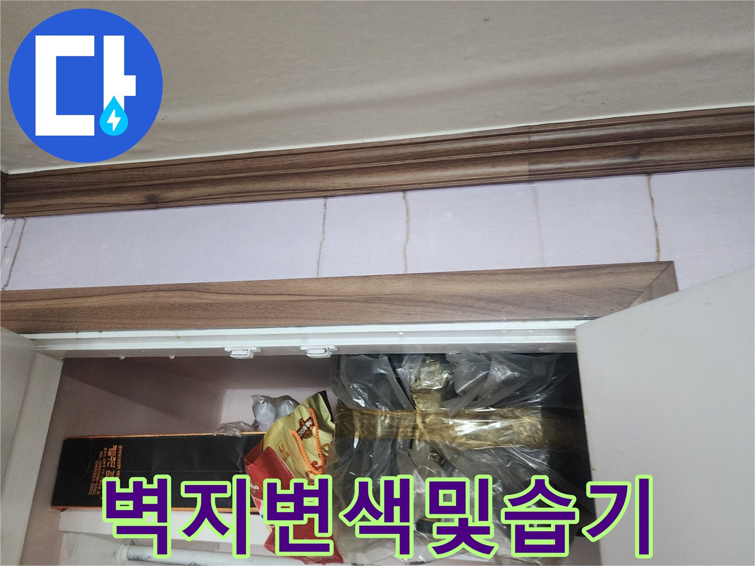 벽면 상단의 갈색 몰딩과 습기로 인해 변색된 벽지 표면 사진