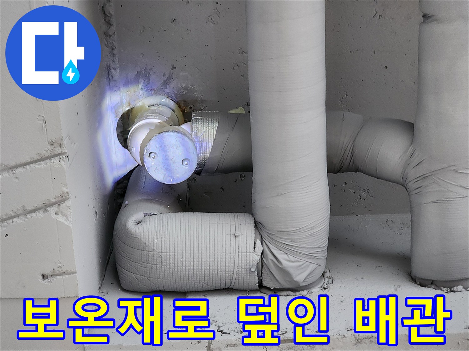 회색 보온재로 감싸진 수직 및 수평 배관 구조