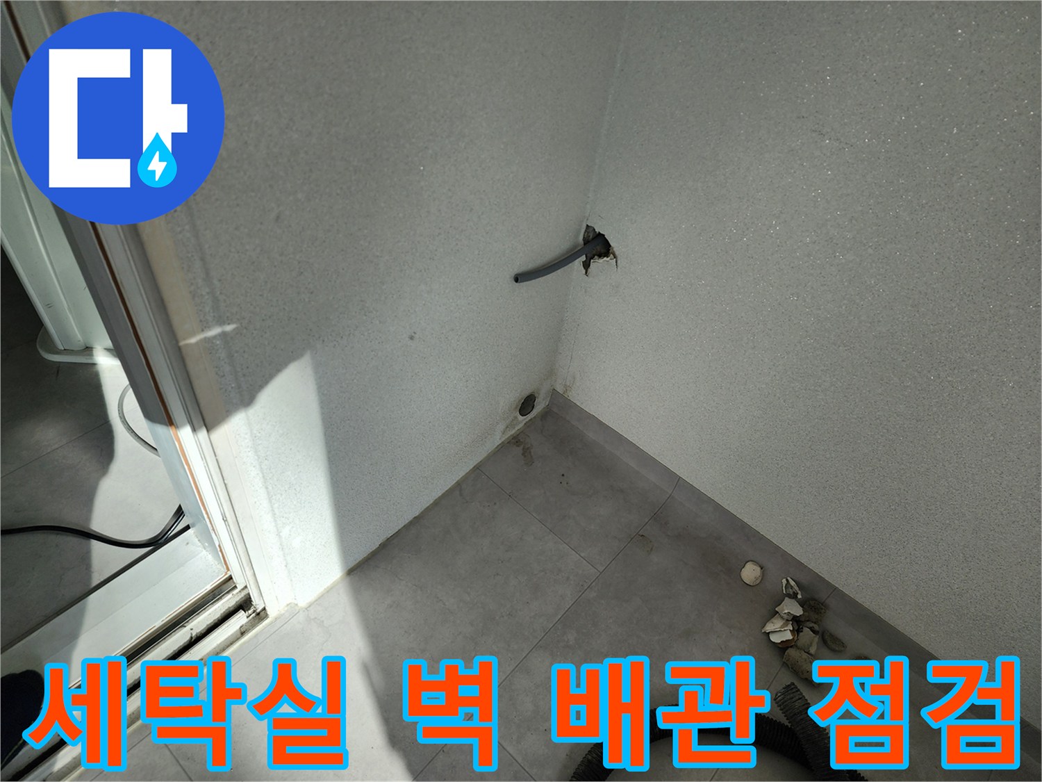 세탁실 배관 주변의 젖은 벽면과 타일 상태