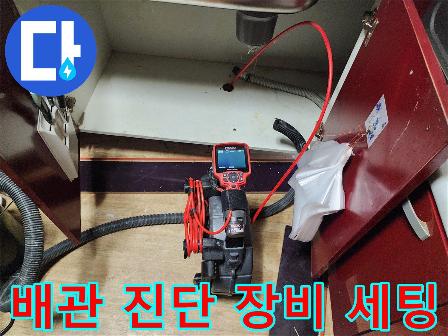 싱크대 하부 배관의 막힘 정도를 파악하기 위한 내시경 카메라와 호스 연결 상태