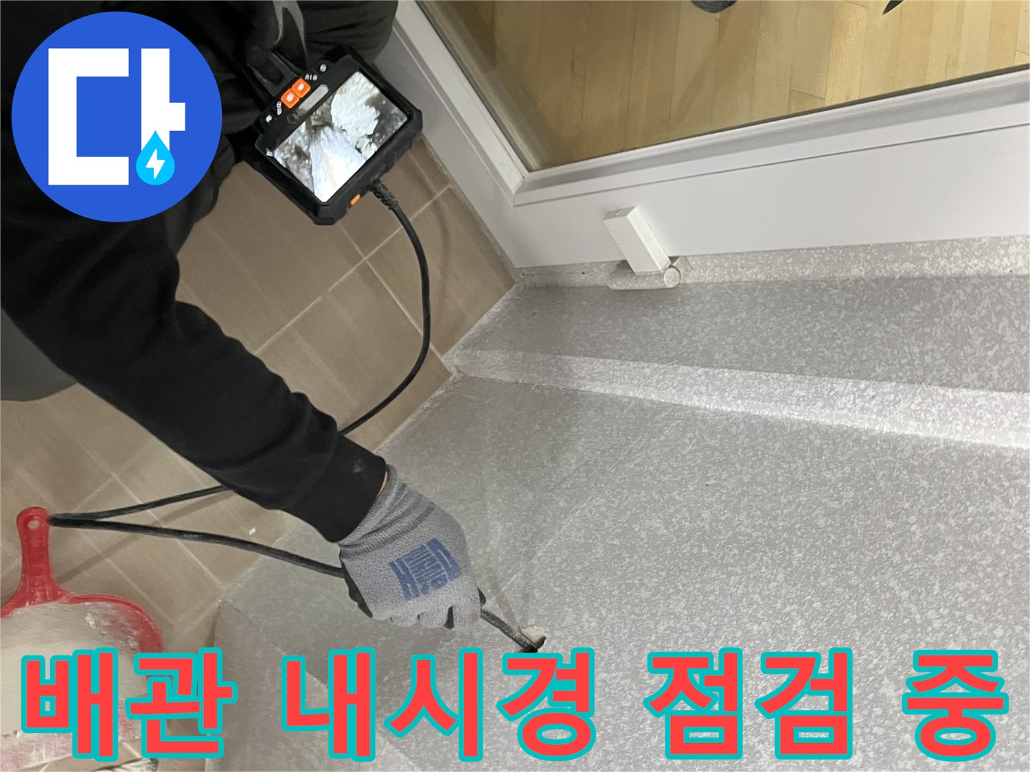 배수관 내부 상태를 확인하기 위해 내시경 카메라를 투입하는 모습입니다.