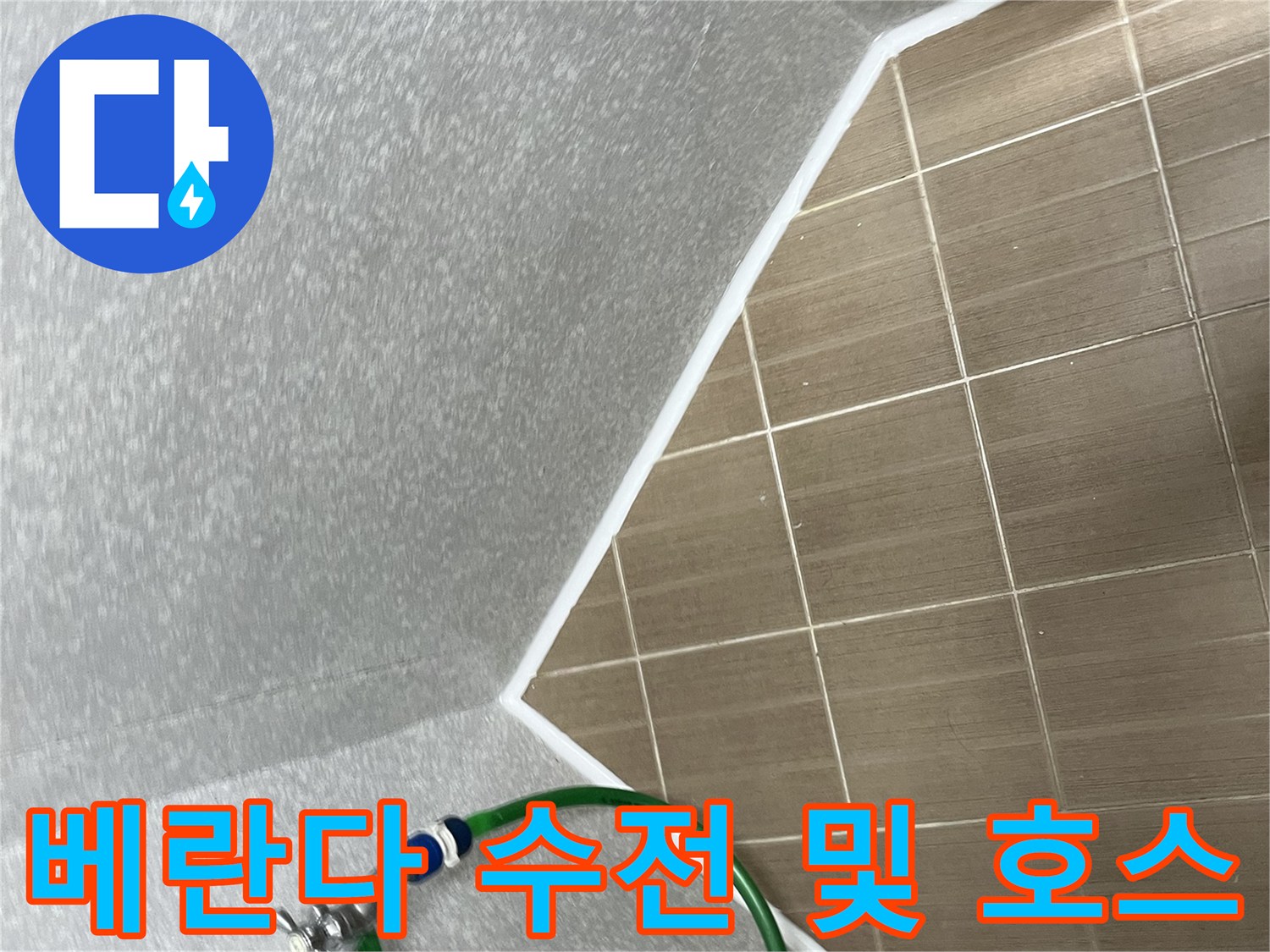 벽면에 설치된 수도꼭지와 연결된 배관 호스의 근접 사진입니다.
