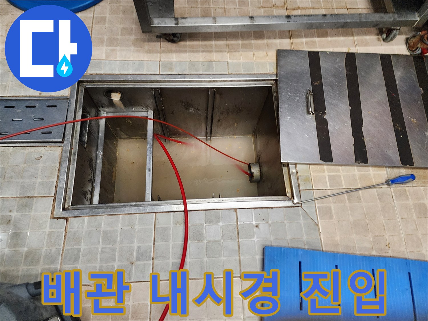 열려있는-점검구 내부의 배관과 움직이는 내시경 선