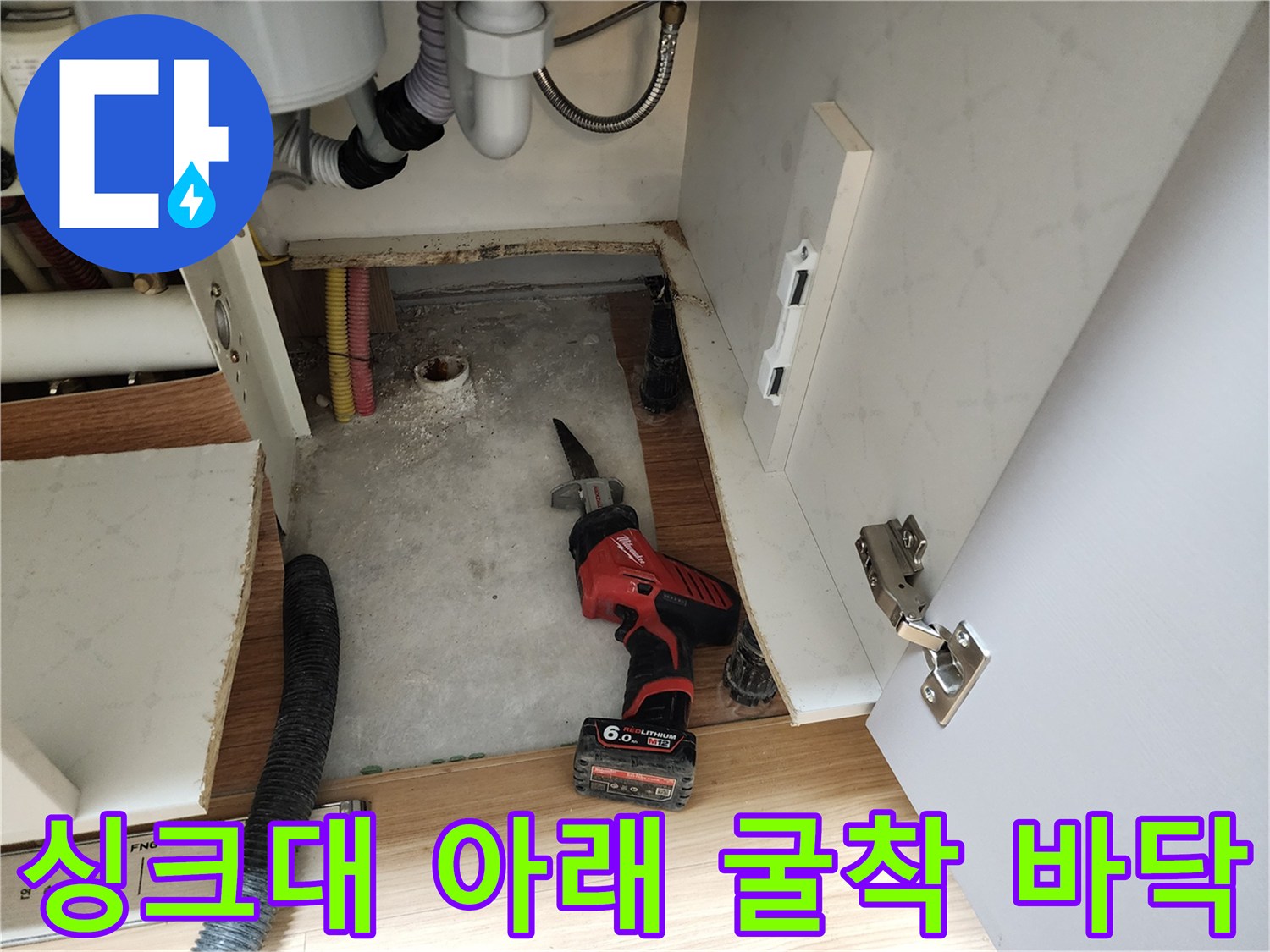 공구와 함께 드러난 싱크대 하부의 젖은 바닥면 - 누수 부위 정밀 진단 중