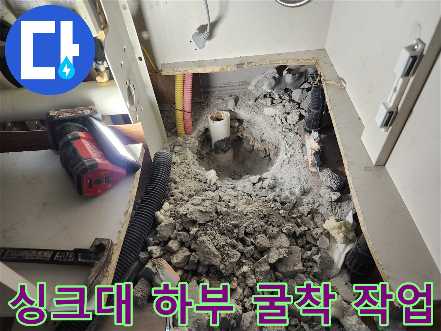 싱크대 아래 바닥을 파내어 누수가 발생하는 배관 부위를 노출시킨 사진입니다.