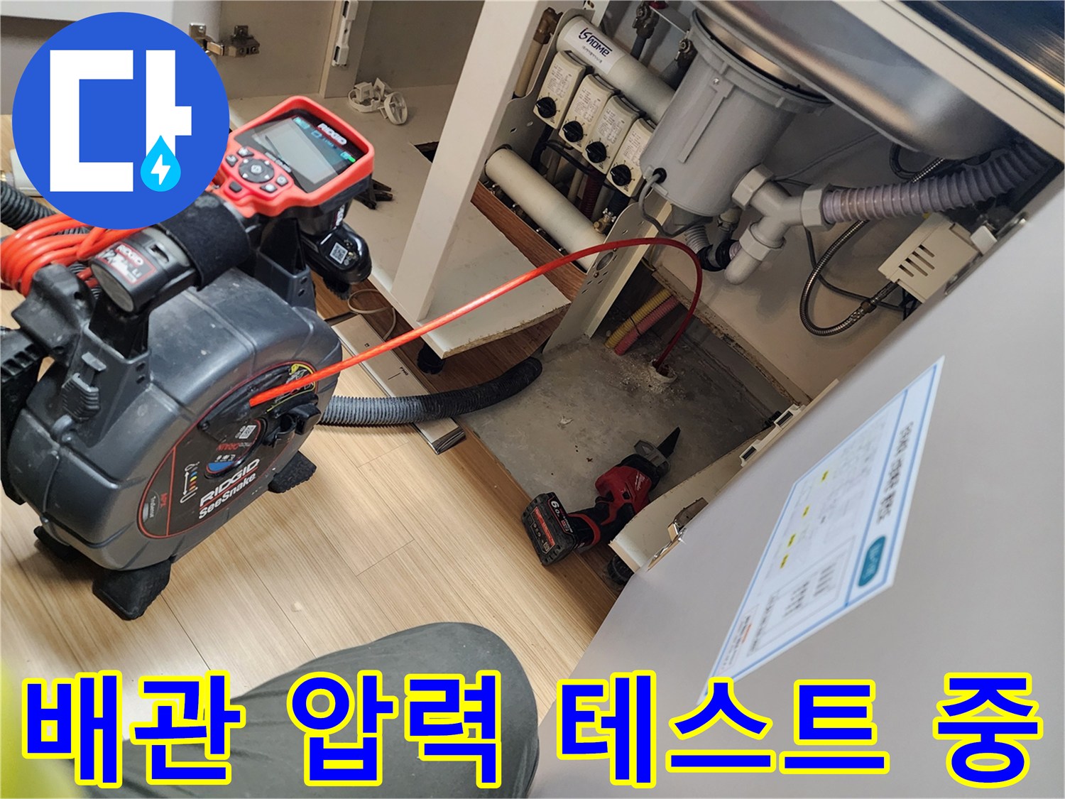 싱크대 하부 배관의 기밀성을 확인하기 위해 공압 테스트기를 연결한 모습입니다.