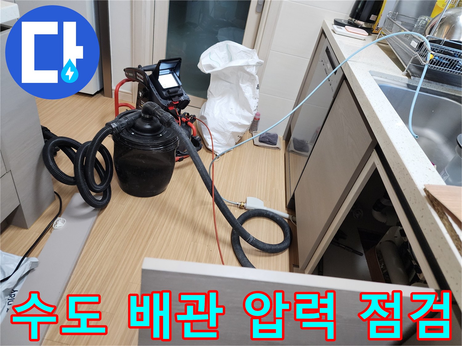 주방 싱크대 하단에 설치된 공압 테스트 장비와 연결 호스입니다.