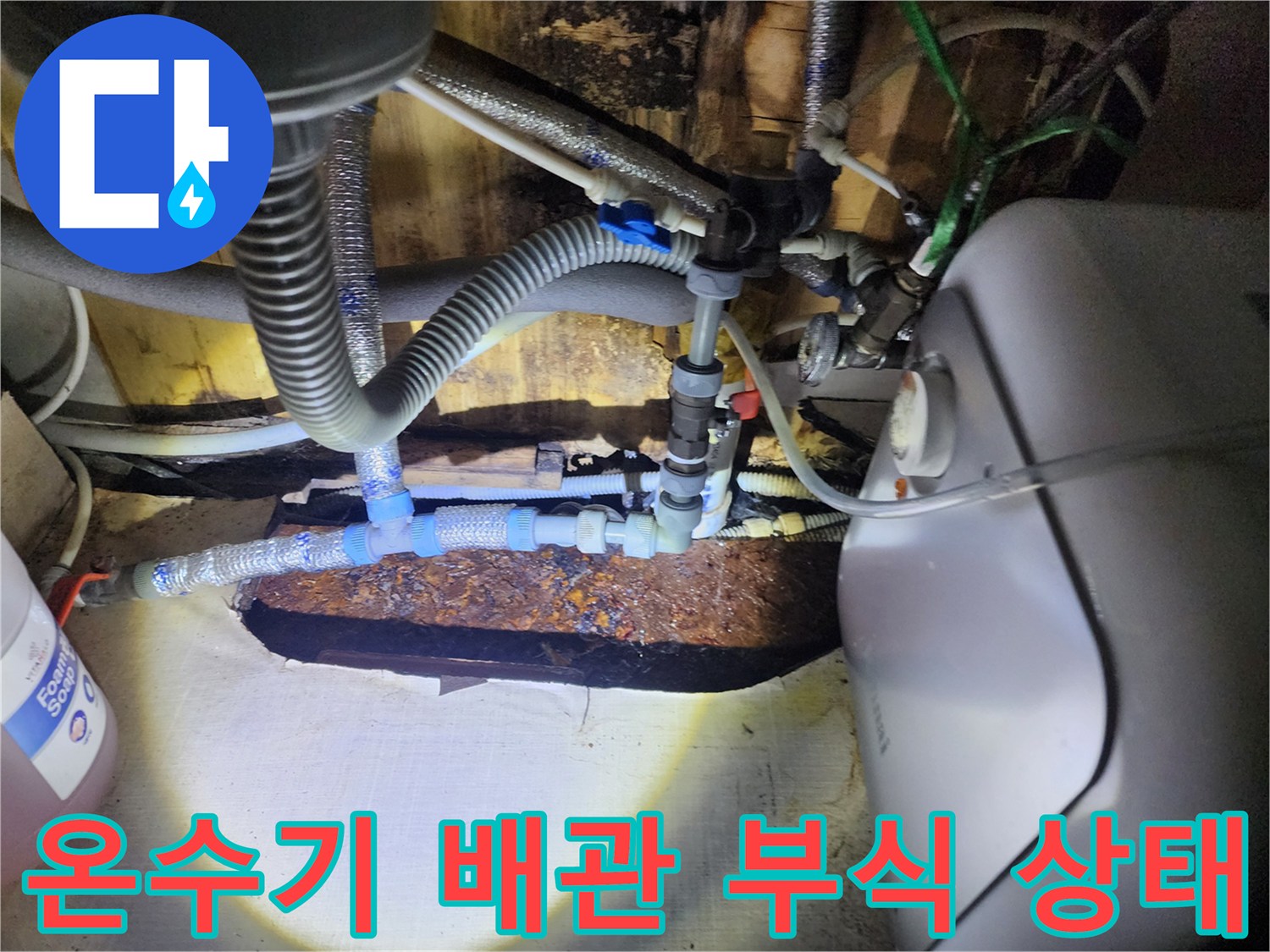 온수기 하단 금속 배관과 연결 호스의 노후된 모습