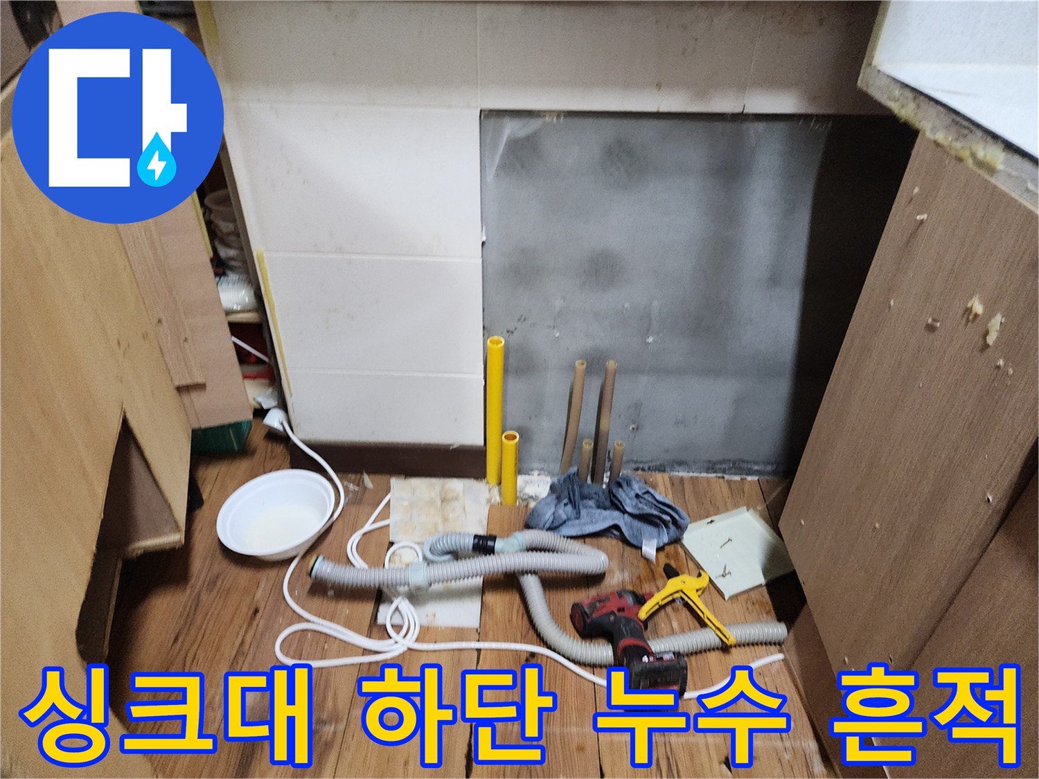 물기가 고여 있는-싱크대 하부장 바닥과 작업 도구들