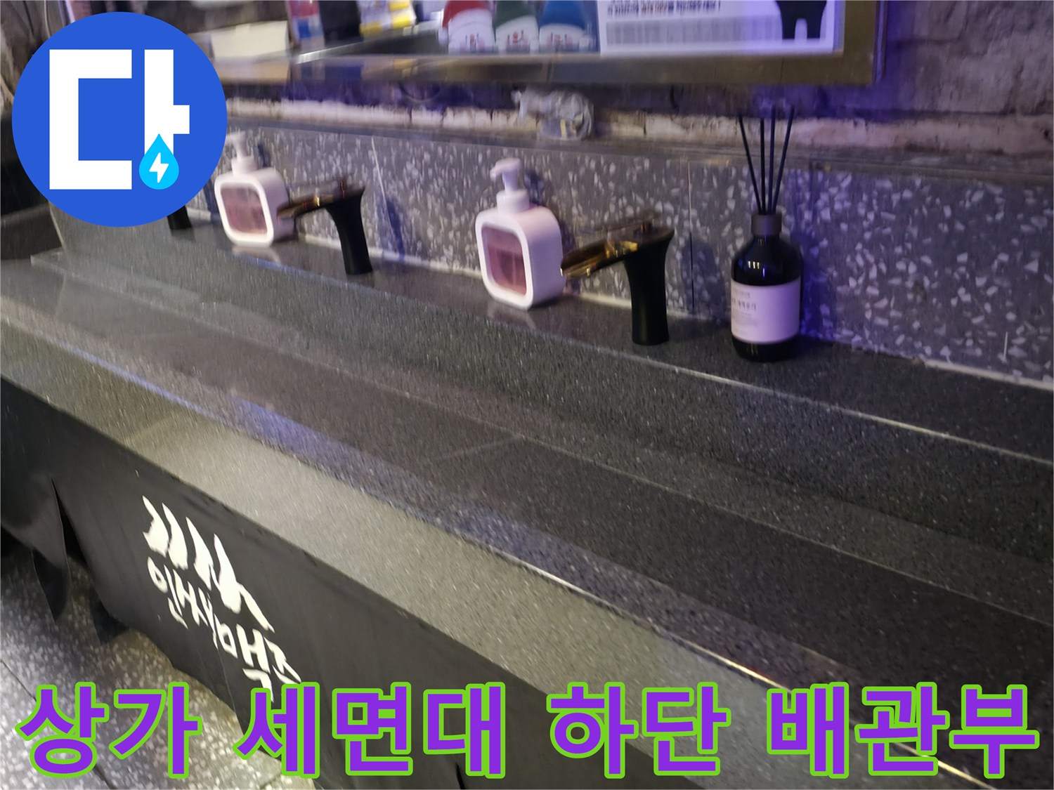 세면대 수전과 벽면 타일이 보이는 상가 화장실 모습입니다.