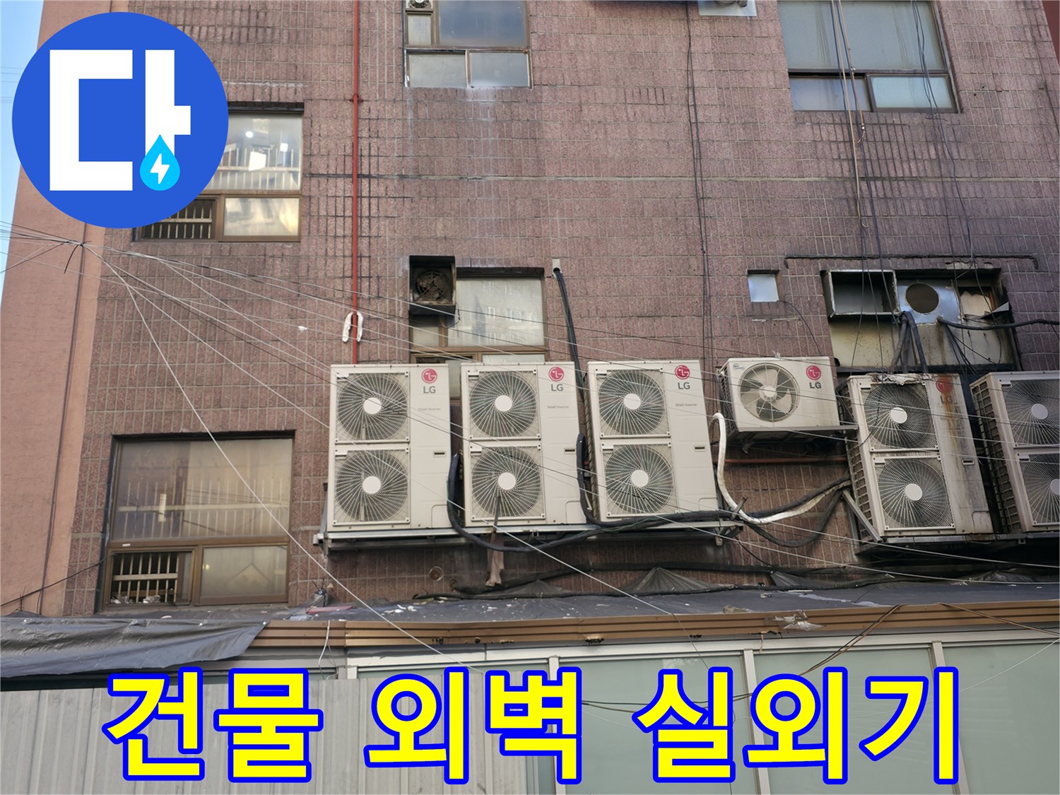 적갈색 벽돌로 된 상가 건물 외벽과 에어컨 실외기 모습