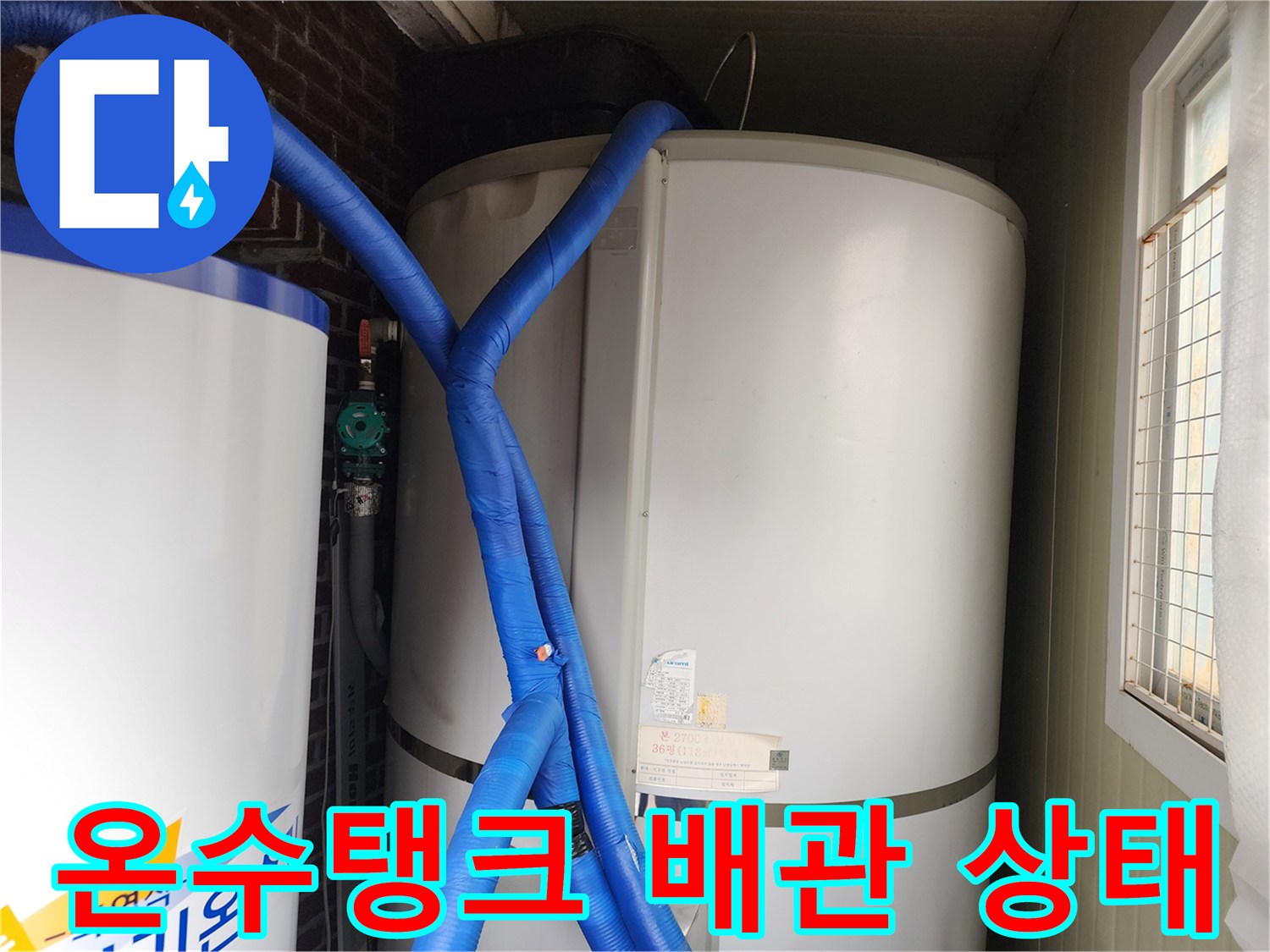 대형 온수 탱크와 파란색 보온재로 감싸진 배관 연결 부위