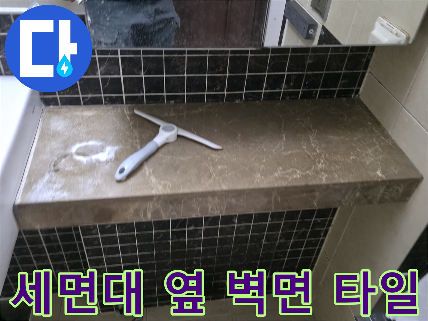 욕실 선반 위 공구와 어두운 색상의 벽면 타일 구조
