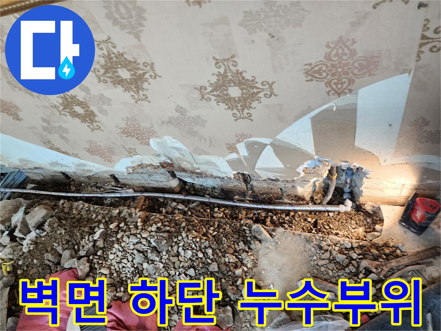 누수 지점 확인-벽지 제거 후 드러난 배관 파손과 젖은 바닥의 모습입니다.