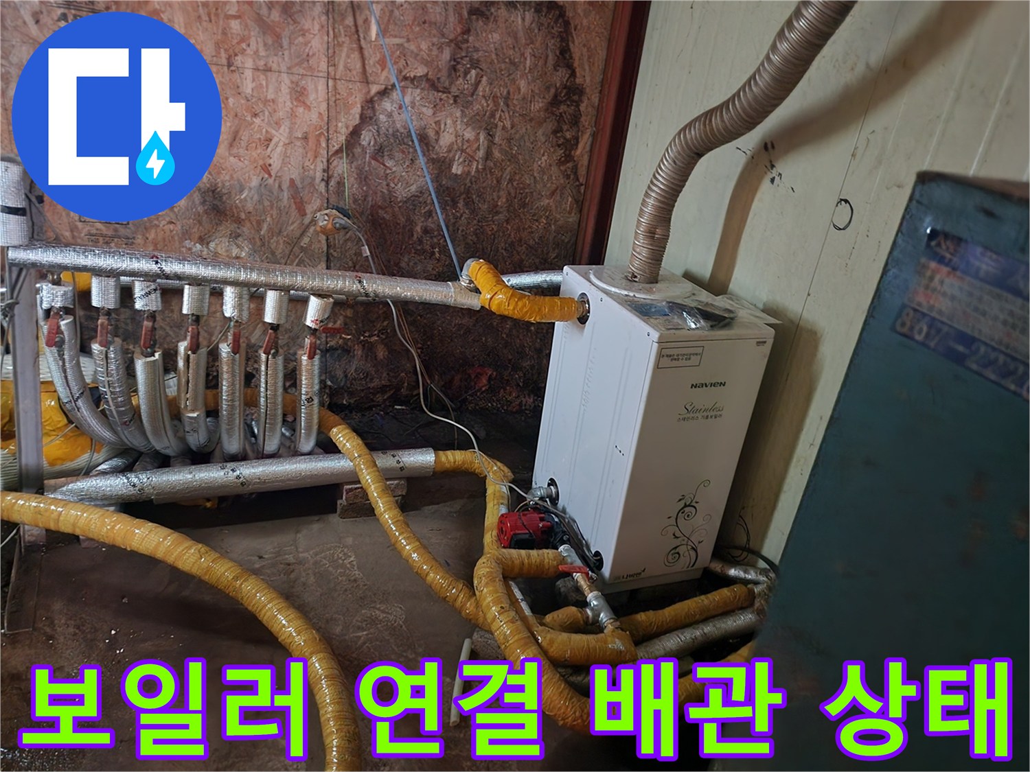 보일러 하단에 연결된 여러 개의 보온재 씌워진 배관들
