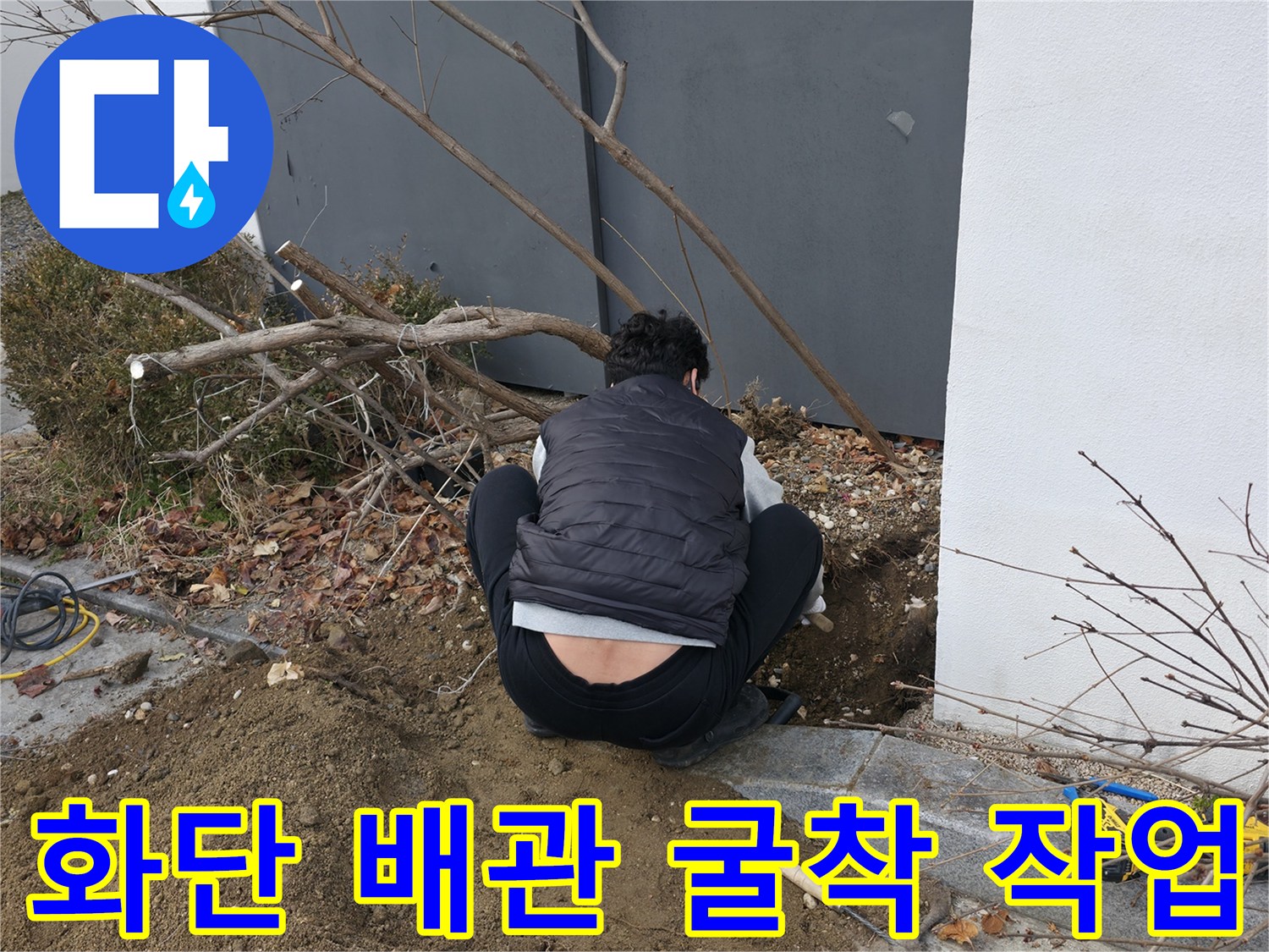 건물 외벽 화단 인근-흙을 걷어내고 배관을 확인하는 모습