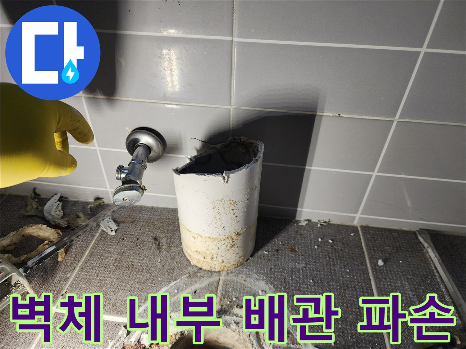 벽면 타일 안쪽의 깨진 배관과 노출된 금속 밸브 부위