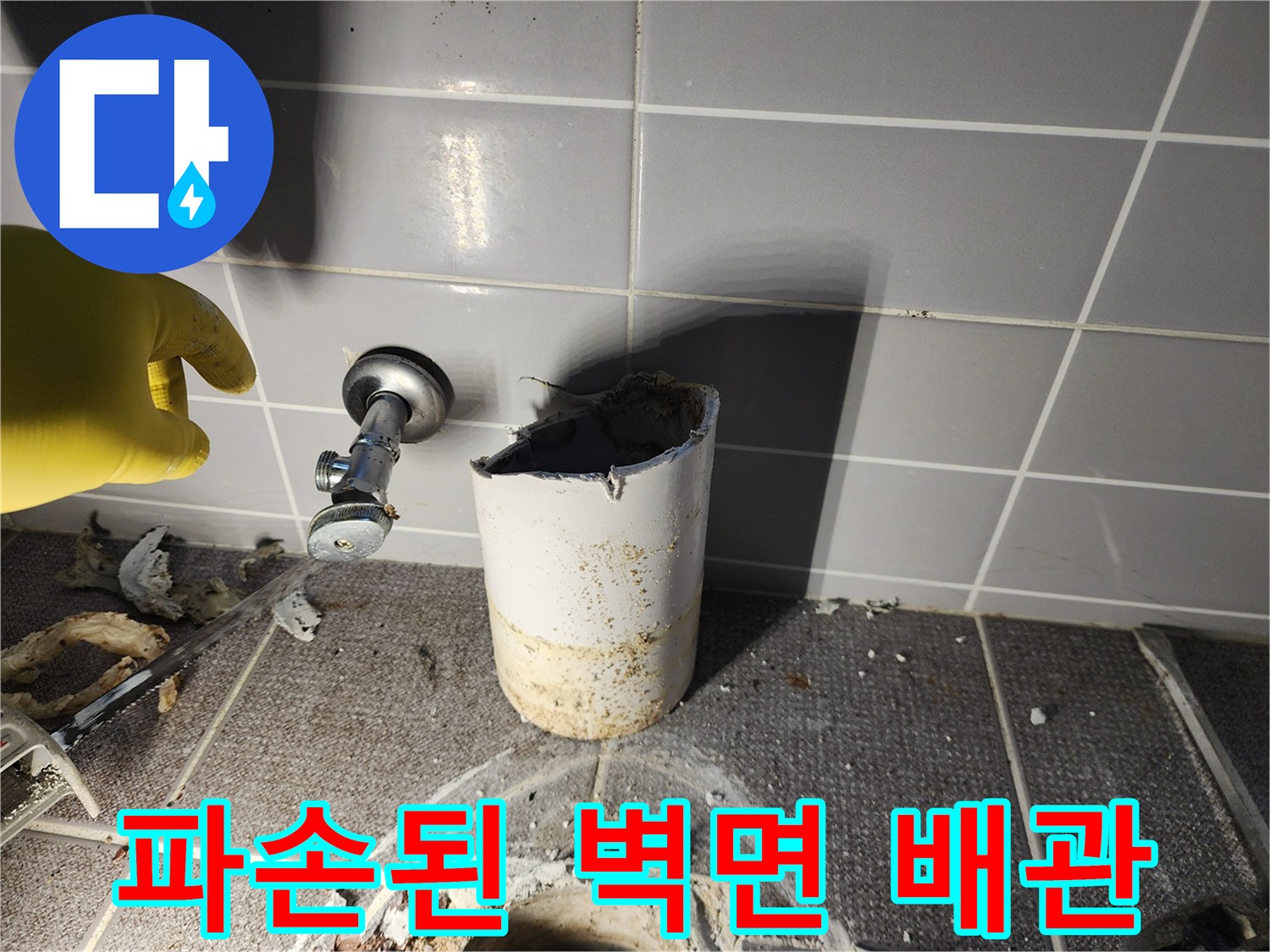 타일이 제거된 욕실 벽면에 노출된 배관과 금속 밸브 부품