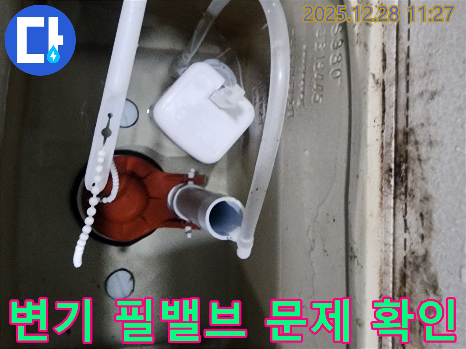 변기 물탱크 내부의 필밸브 작동 상태를-확인하여 물 넘침 원인을 파악하는 모습