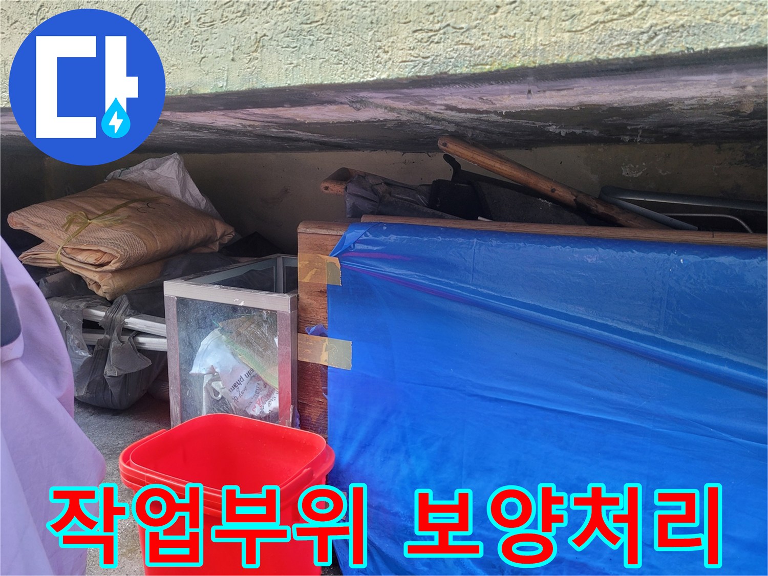 파란 비닐과 자재들을 활용하여 누수 수리 부위를 보호하는 모습입니다.
