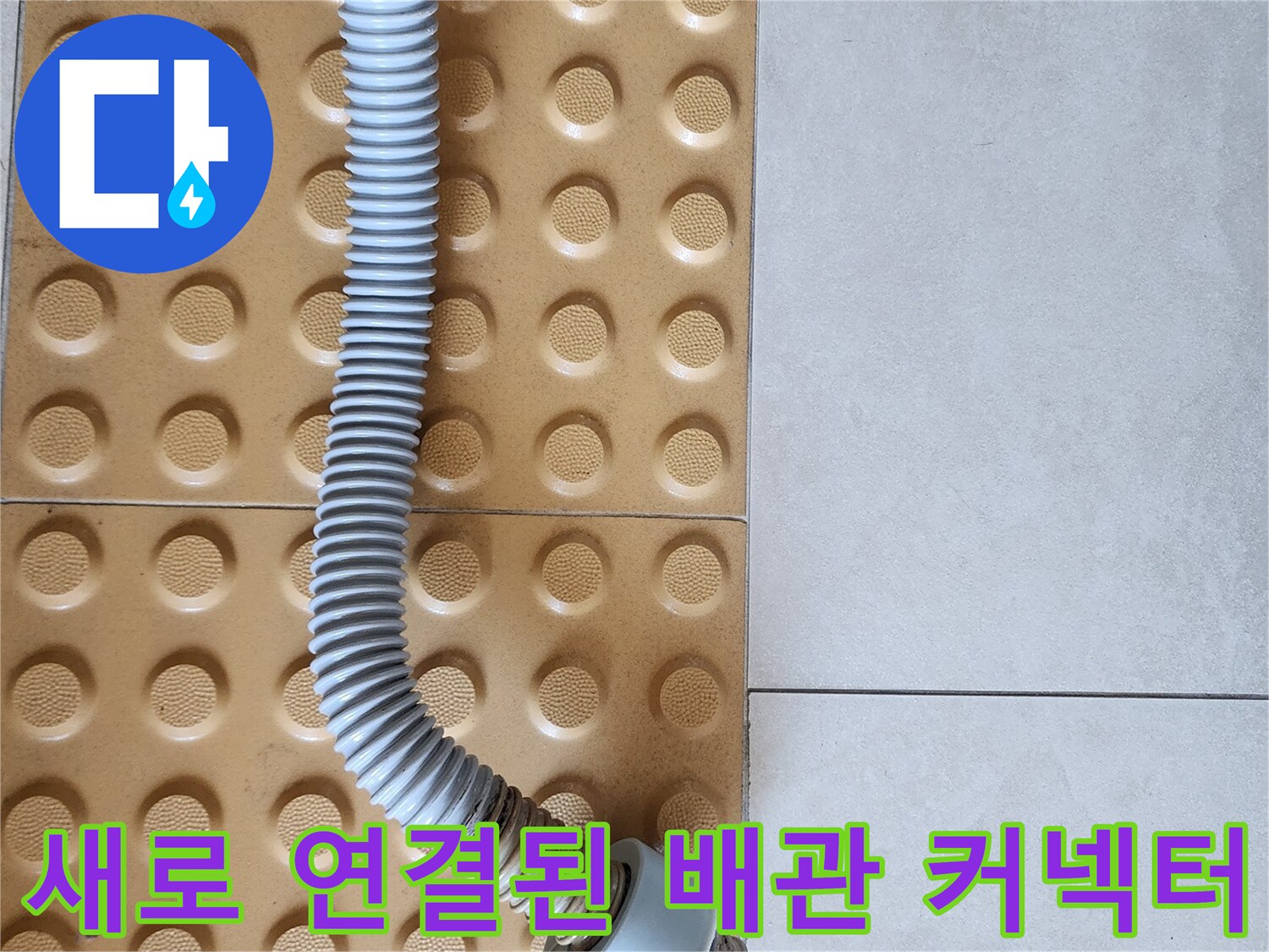 노란색 돌기 타일 위에 놓인 흰색 주름 배관 부속
