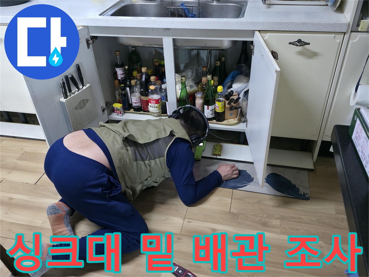 싱크대 하부 수납 공간 내 배관 누수 여부를 확인하는 엔지니어