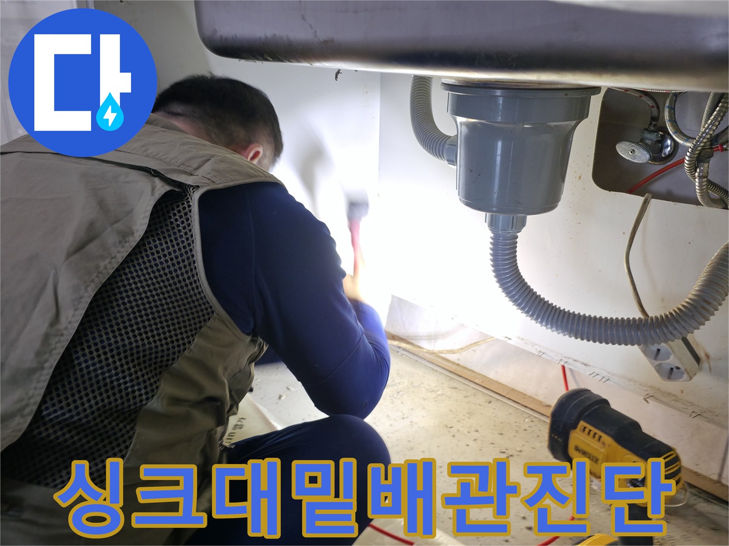 싱크대 하부의 배수 호스와 벽면 급수 밸브를 점검하는 모습