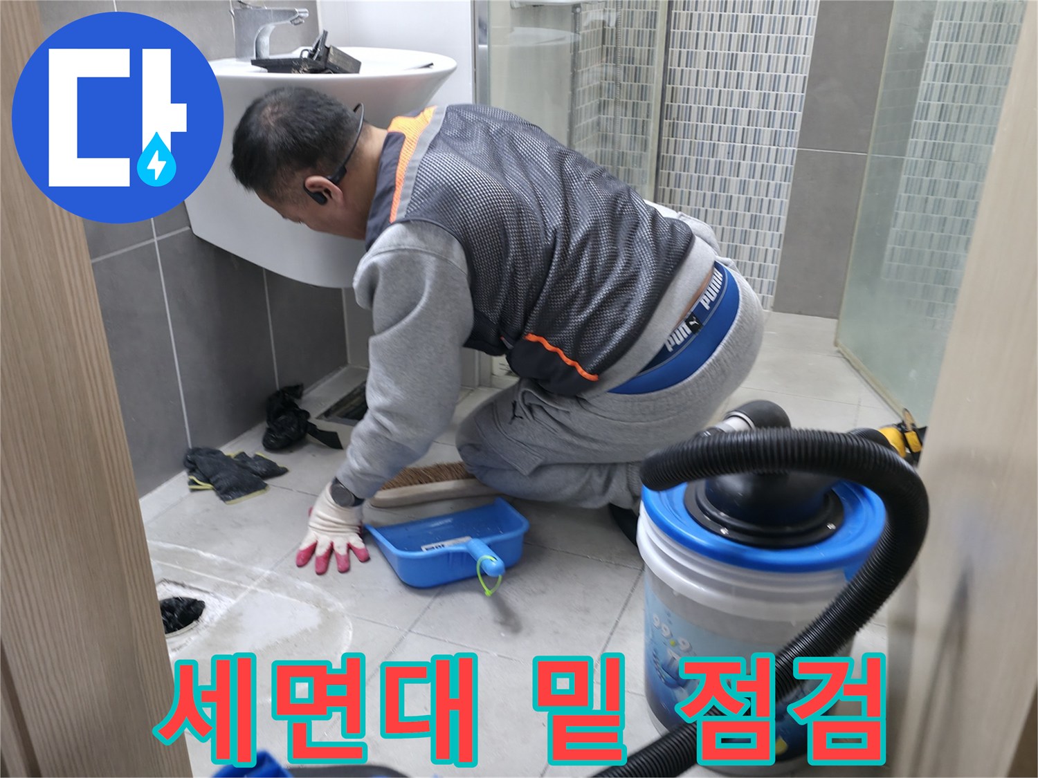 하남 현장-세면대 아래쪽 타일 틈새를 살피는 작업자