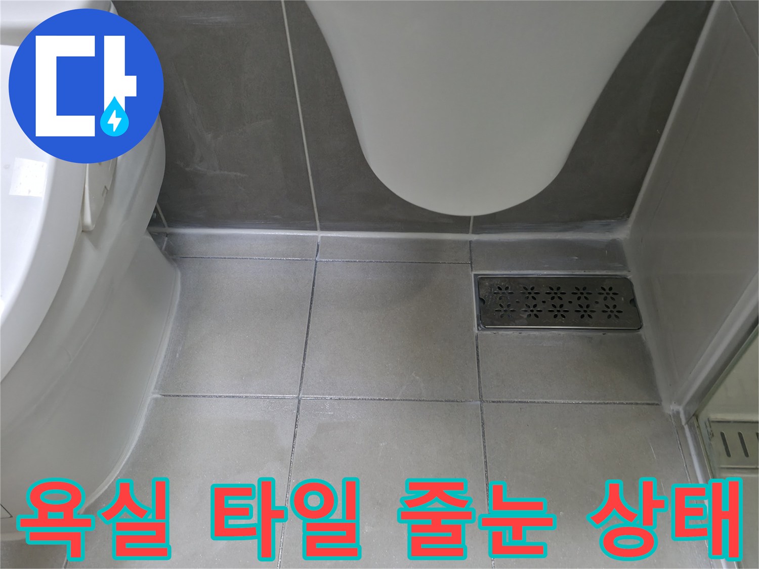 화장실 변기와 바닥 배수구 사이의 타일 간격을 촬영한 사진입니다.