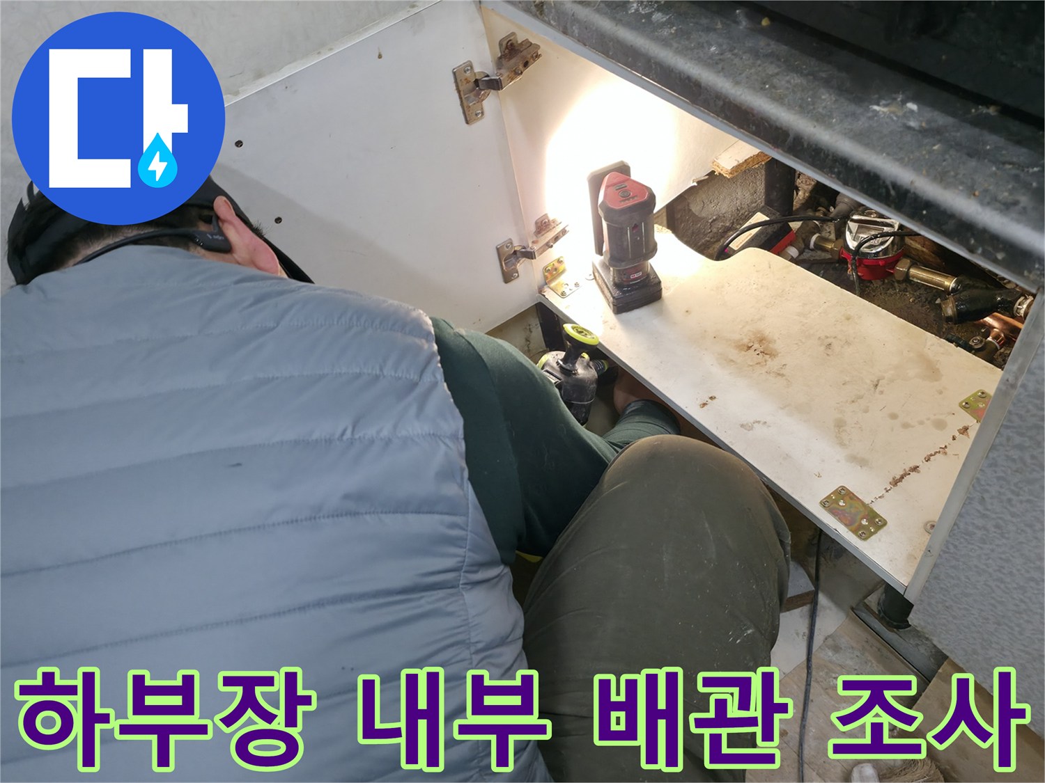 싱크대 밑 배관-누수 여부를 확인하는 작업자